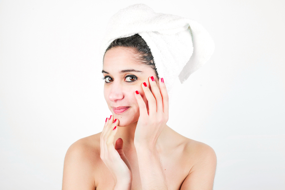 Woman with a towel wrap showing clear skin and polished nails